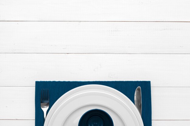 Photo empty plate and towel over wooden table background.