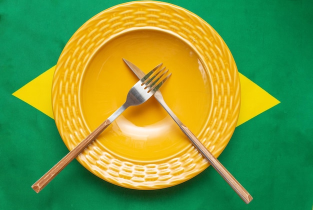 Empty plate with cutlery over brazilian flag