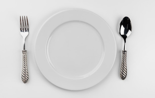 Empty plate with cutlery isolated on white background