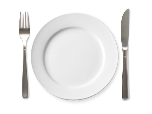 Empty plate with knife and fork on a white surface