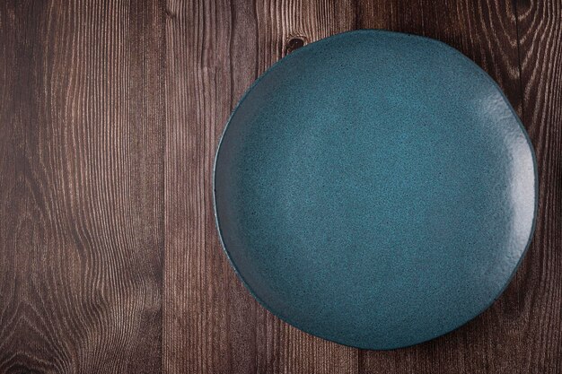 Empty plate on the wooden table Top view of the image