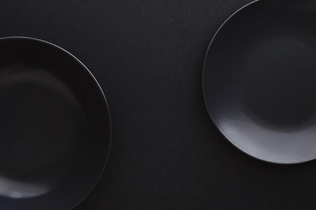 Empty plates on black background premium dishware for holiday dinner minimalistic design and diet