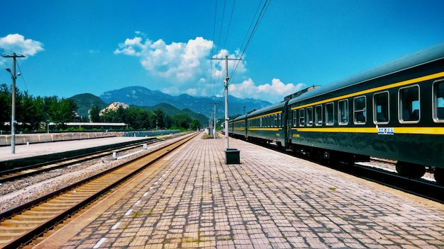 empty railroad station by mountain against sky