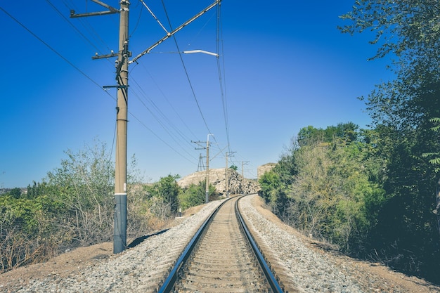 山の中の柱のある空の鉄道