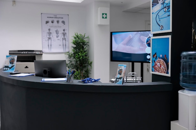 Empty reception counter with no people at private practice\
clinic, hospital waiting room for consultation appointments.\
hospital waiting room front desk with office supplies and\
promotional flyers.