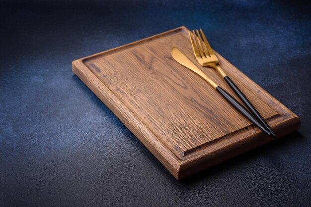 Empty rectangular wooden cutting board on dark concrete background