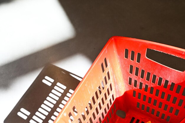 Empty red shopping cart in sunlight shadows space copy Shopping concept trend visual