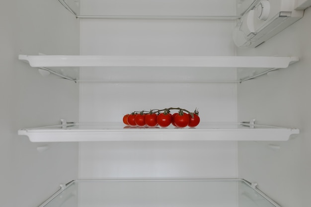 Пустые полки холодильника только с помидорами черри