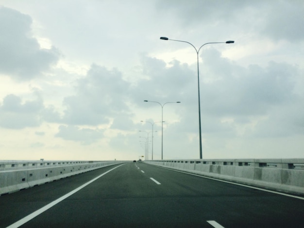 empty road against cloudy sky