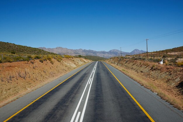 Empty road along countryside landscape