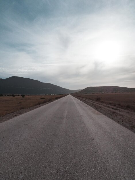 Foto strada vuota lungo il paesaggio contro il cielo