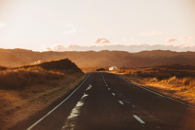 Empty road along landscape against sky