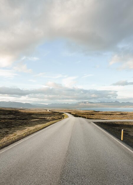 Foto strada vuota in mezzo al campo contro il cielo