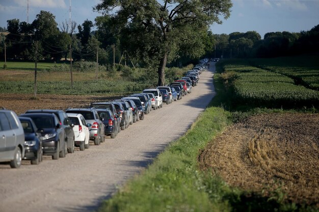 Foto strada vuota in mezzo agli alberi sul campo contro il cielo