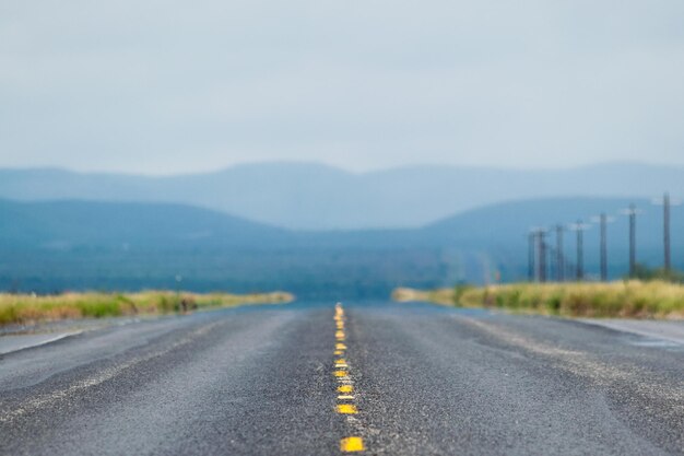 Photo empty road by mountains against clear sky