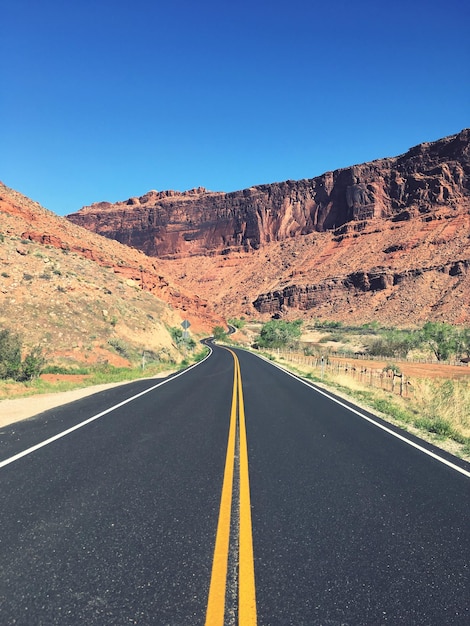 Foto strada vuota tra le montagne contro il cielo