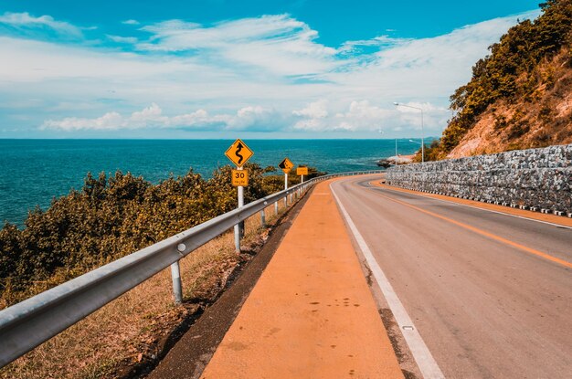 Foto strada vuota sul mare contro un cielo nuvoloso