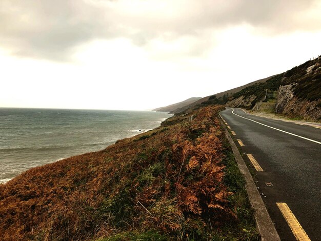 Photo empty road by sea against sky