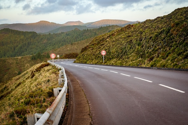 Empty road in the mountains. Sunset. No overtaking sign