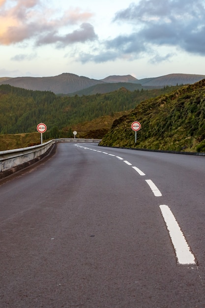 Empty road in the mountains. Sunset. No overtaking sign