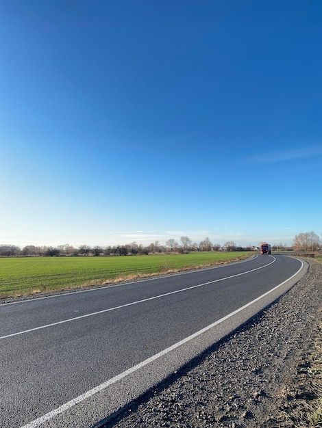 Empty road near green field on a sunny day