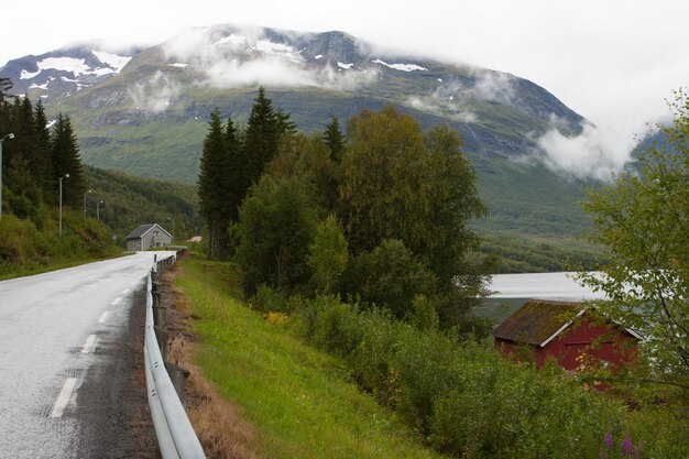 ノルウェーの山々の空の道と田舎の家