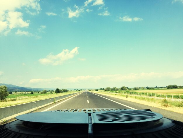 Empty road seen over car bonnet