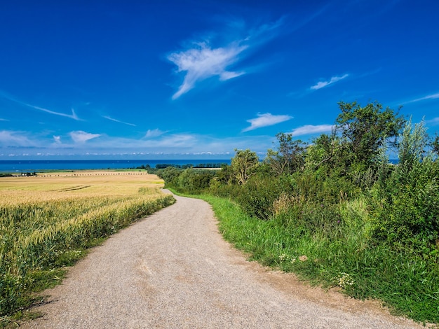 Photo empty road towards sea against blue sky