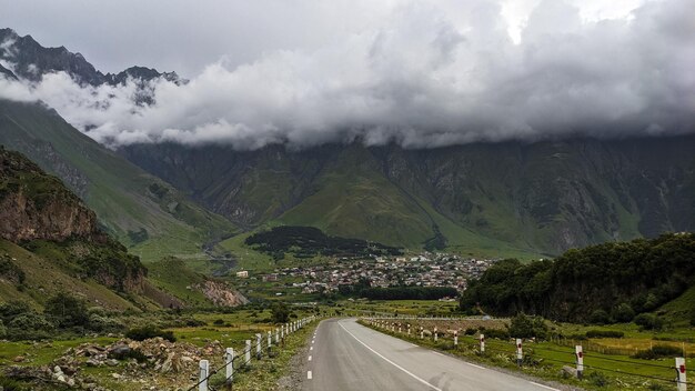 Empty road to the village next to the mountains