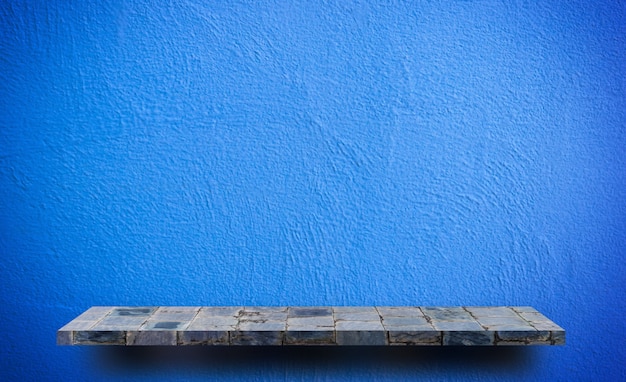 Empty rock stone shelf on blue wall background