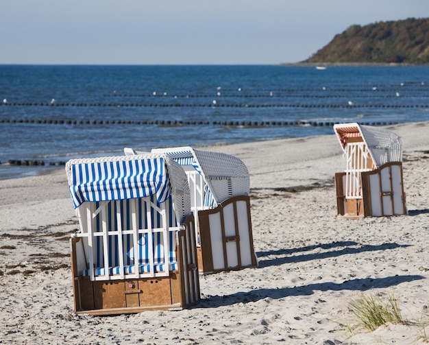 Empty roofed wicker beach chairs on the beach, Ruegen, Germany