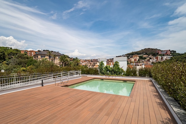 Empty rooftop with swimming pool. View to a city and mountain