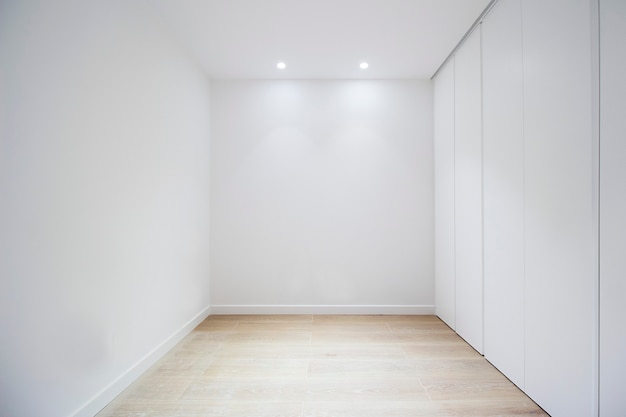 Empty room with door closets and white walls