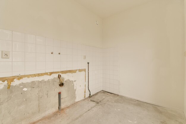 An empty room with white tiled walls and floor