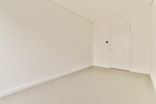 An empty room with white walls and a door