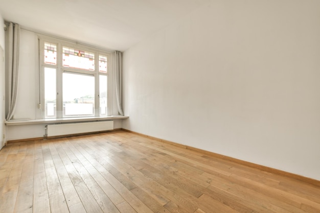 an empty room with wood floors and a window