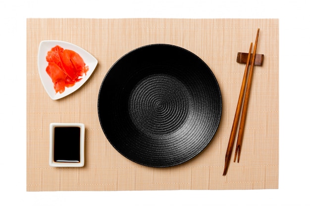 Empty round black plate with chopsticks for sushi