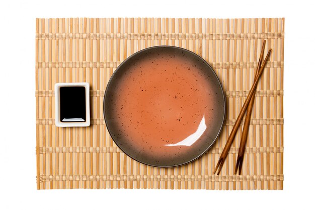 Empty round brown plate with chopsticks for sushi