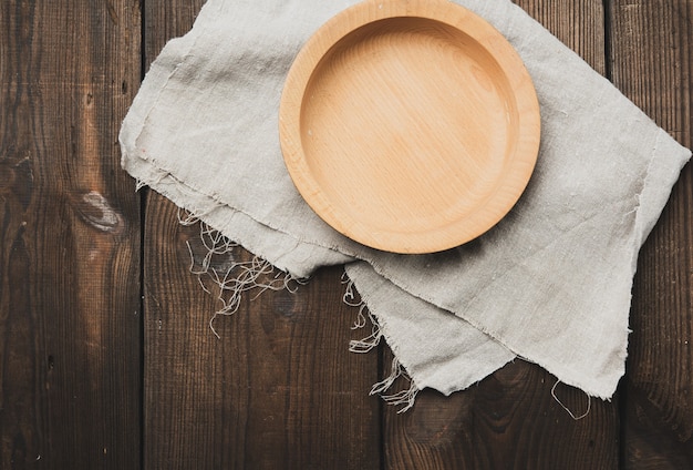 Empty round brown wooden plate on table, top view