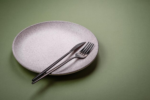 Empty round ceramic plate on a plain background flatley with copy space