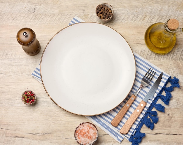 empty round white plate olive oil spices on wooden table
