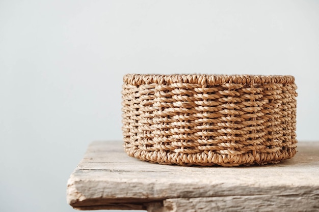 Empty round wicker basket on a old wooden table. Copy, empty space for text