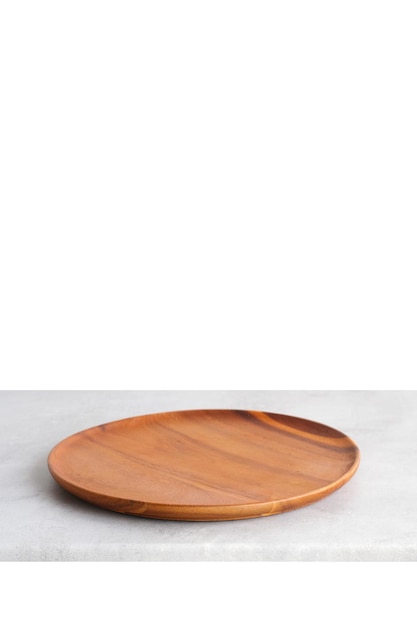 Пустая круглая деревянная тарелка на фоне серого цементного стола