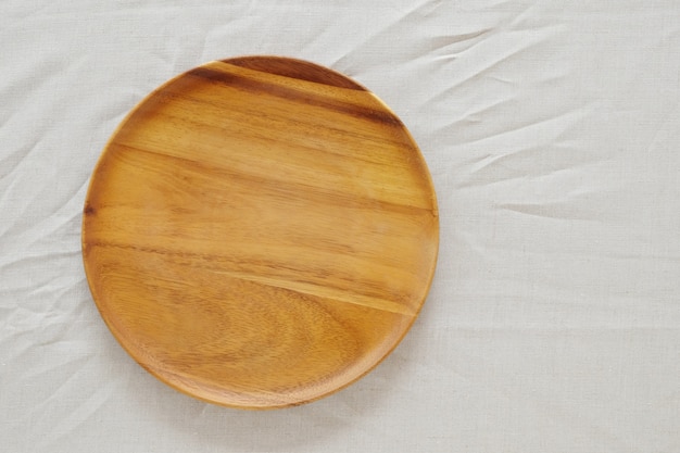 Svuoti il piatto di legno rotondo sulla tavola, montaggio dell'esposizione dell'alimento