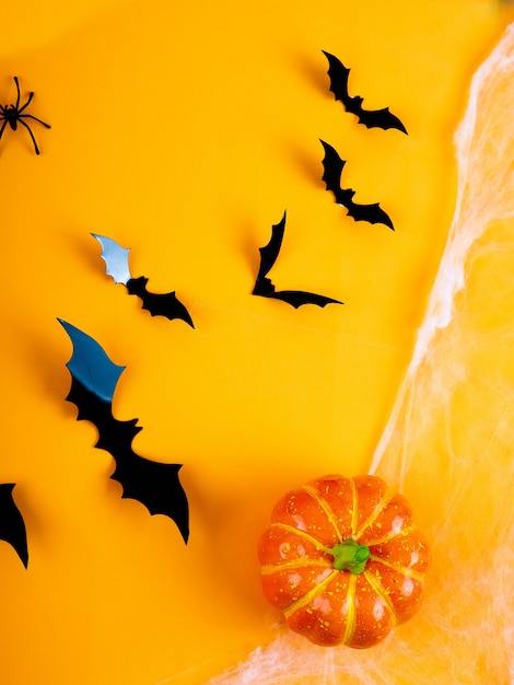 Empty rustic table in front of spider web background, orange background with bats and cobwebs, Halloween 