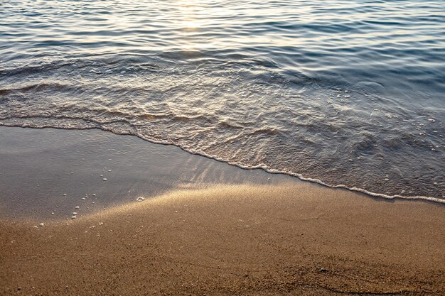 Empty sandy beach at sunset greece overhead sea water touch wet\
sand copy space summer holiday