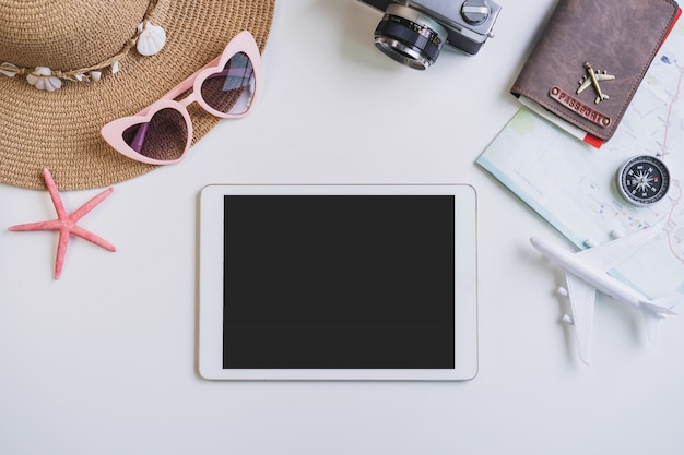 Empty screen tablet with travel accessories and items on white background with copy space, Travel concept