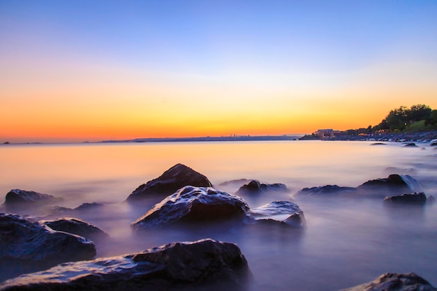 空の海と岩夕焼けのシルキーシーとの長時間露光のため、NDフィルター画像を使用して設計します