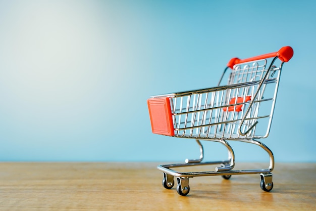 Empty Shopping cart on blue background with copy space on the right side