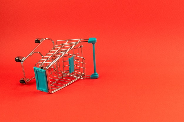 Empty shopping cart on bright red background 